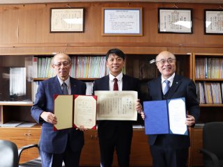 田中佑治助教（中央）と上本伸二学長（左）、遠山育夫理事（右）